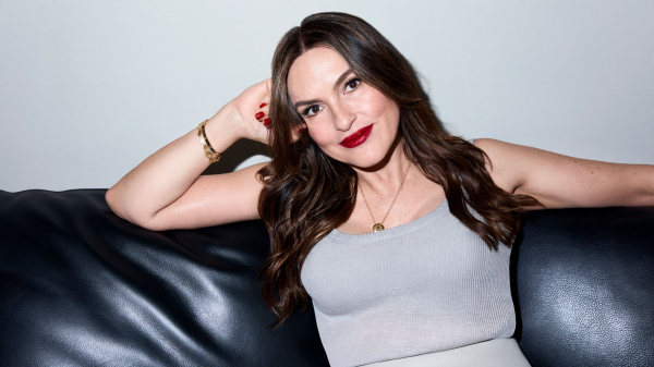 Mariska Hargitay sitting on couch with red lipstick and nail polish